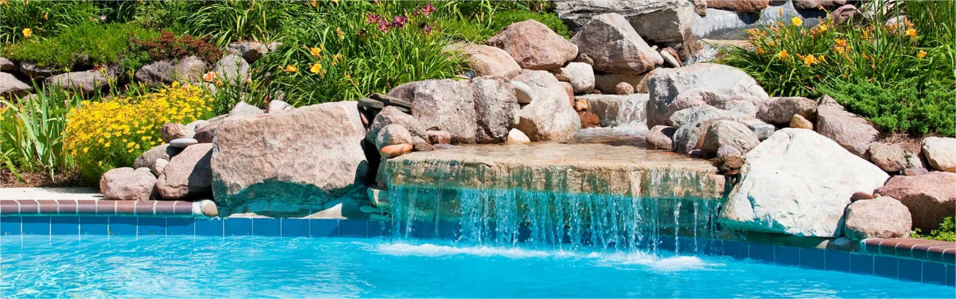 Rock fountain next to swimming pool