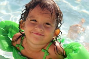 Small child in water with floaties