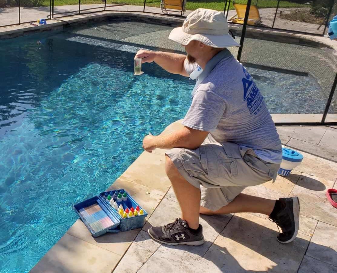 man testing pool water quality
